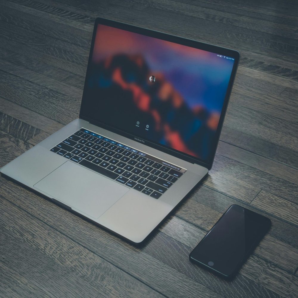 pexels-photo-303383-303383 A sleek laptop and smartphone placed on wooden flooring, showcasing contemporary technology.